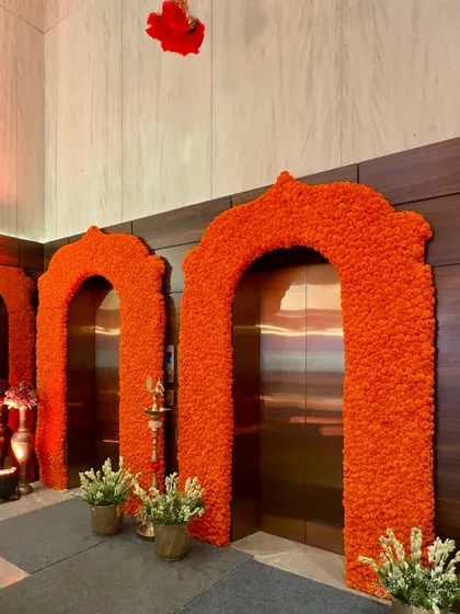 Another angle of the marigold arches, highlighting the traditional lamp placed between them, blending auspicious symbols with vibrant floral design.
