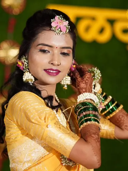 A lovely candid shot showing the bride adjusting her floral jhumkas. The mix of pink, blue, and yellow flowers in her set was customized to match her vibrant personality.