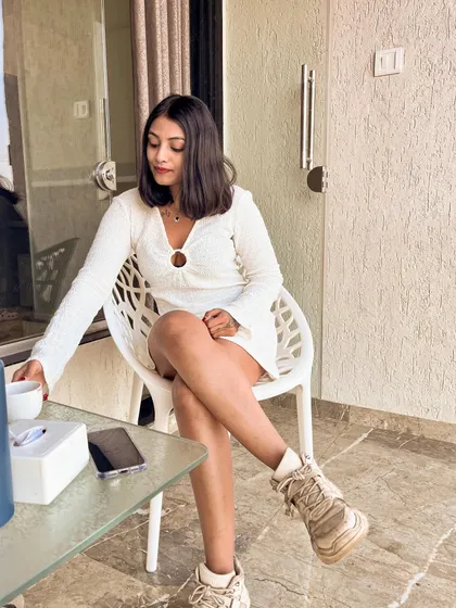 Sitting on the balcony in my white dress and chunky sneakers. This is my go-to combination for a comfortable yet stylish travel outfit.