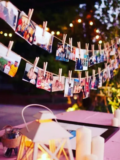 A charming outdoor photo garland for an evening celebration. I hang your pictures using clothespins on a string of fairy lights, creating a warm and personal atmosphere.