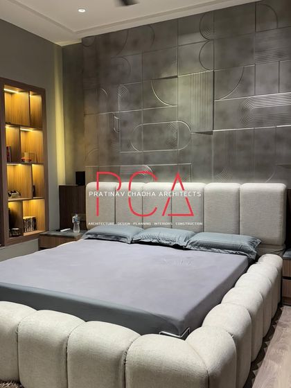 The completed son's room, featuring the custom bed with a bouclé fabric frame and a headboard set against the striking metallic accent wall. The integrated side tables and warm lighting complete the luxurious, cohesive look.