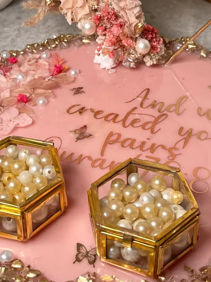 A detailed shot of the pearl-filled ring boxes and the intricate pearl and gold border of the tray.