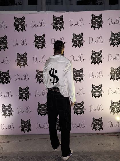 Posing for a photo, this client shows off the back of his made-to-order shirt. I work with you to create designs that are not just clothes, but conversation starters.