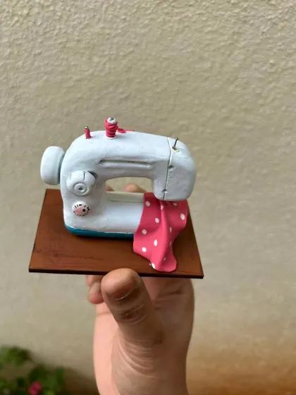 Another view of the miniature sewing machine. The tiny details, like the thread and polka-dot fabric, make it extra special.
