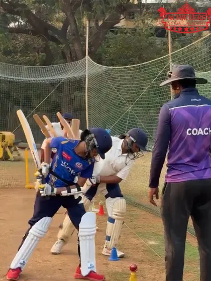 A coach working closely with a young batsman, adjusting his grip and stance. This personalized attention helps correct flaws early.