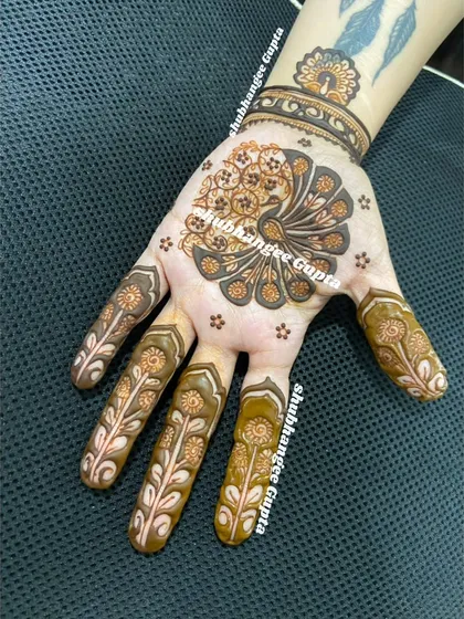 This design shows how a single, powerful motif can be the star. The peacock on the palm is created with two different techniques, giving it texture and depth, while the fingers have a delicate, matching floral design.