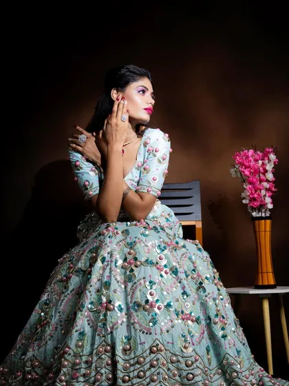 An elegant pose that highlights the beautiful embroidery of the lehenga and the complementary makeup.