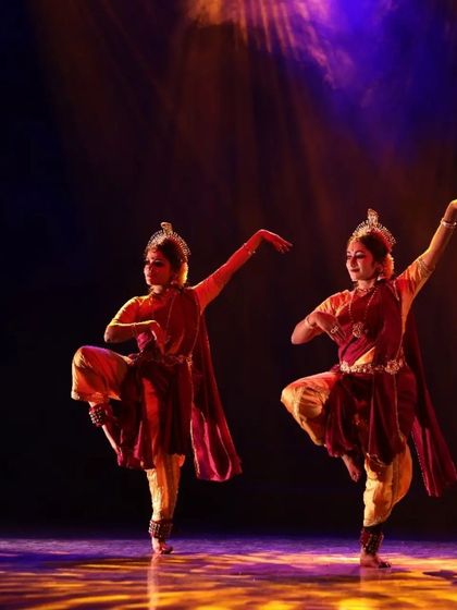 A beautifully synchronized moment from "Shrishti Stithi Laya". The three dancers move as one, their forms highlighted by dramatic spotlights, embodying the principles of creation, preservation, and dissolution.