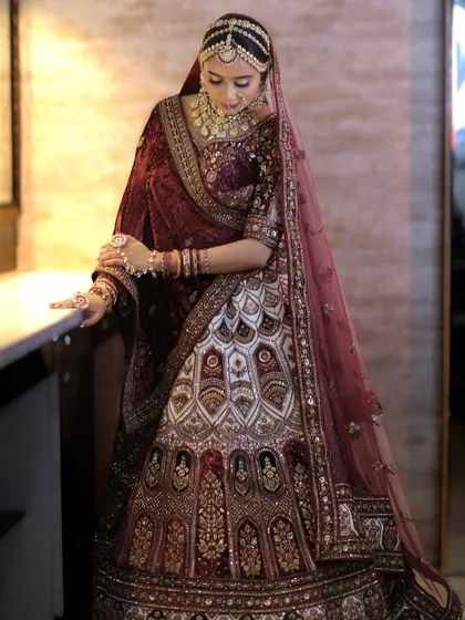 A full-length shot capturing the grandeur of the velvet lehenga and the complete jewellery set. The layered necklaces and matha patti create a truly majestic silhouette.