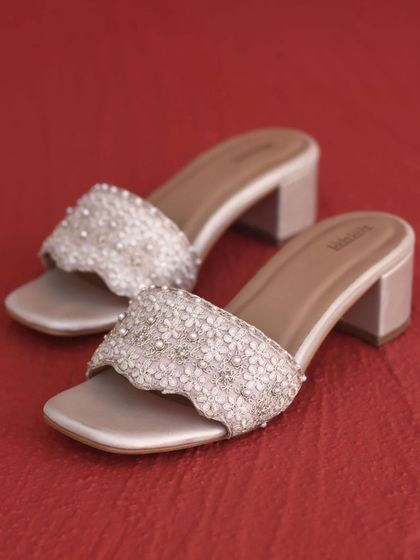 These block heels are detailed with delicate 3D flowers and pearls. They provide a comfortable lift, making them an ideal footwear choice for long hours of celebration during a mehendi or wedding.