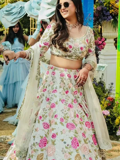 The bride looking chic and happy in her sunglasses, with her floral lehenga perfectly suited for a sunny, outdoor celebration.