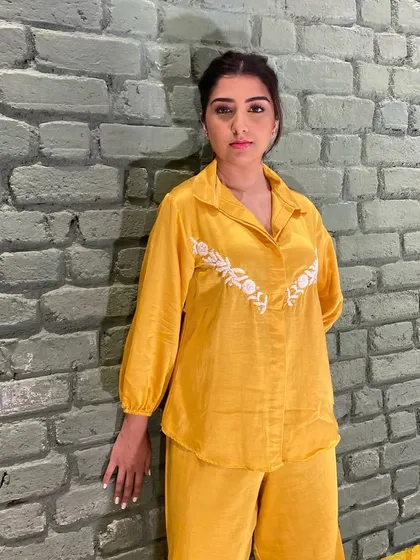 A still from the Beehive Kunjal shoot. This look features a clean, braided hairstyle and subtle makeup to complement the bright yellow outfit.