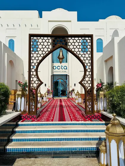 A grand entrance for a welcome lunch in Doha. The traditional archway, patterned rug, and golden lanterns create an authentic and luxurious Middle Eastern experience.