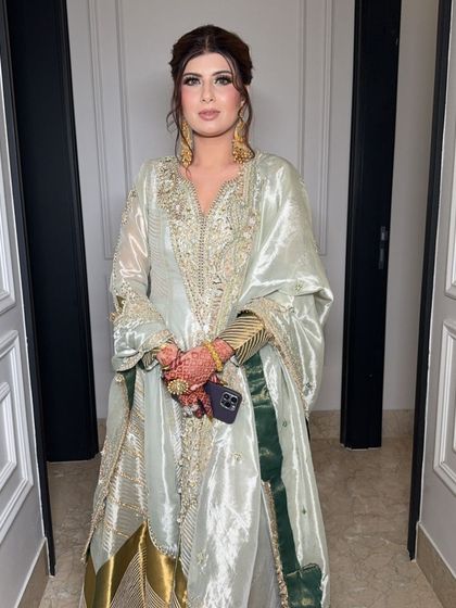 The full look. The soft, glowing makeup is the perfect complement to her elegant, mint green outfit.