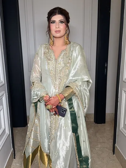 The full look. The soft, glowing makeup is the perfect complement to her elegant, mint green outfit.
