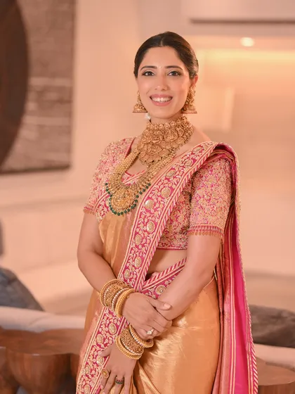 The bride looks radiant in her traditional Kanjeevaram saree, with her hair styled in a classic floral braid that completes the look.