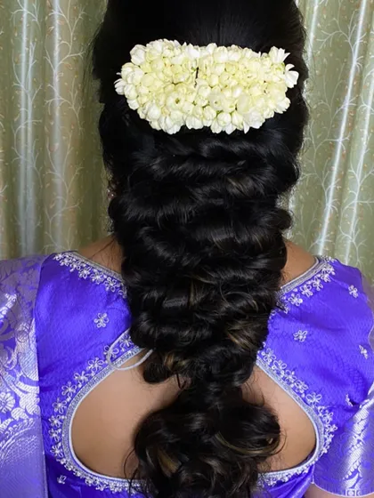 A lovely pull-through braid adorned with a simple jasmine gajra. This hairstyle offers a modern texture while maintaining a touch of traditional elegance.