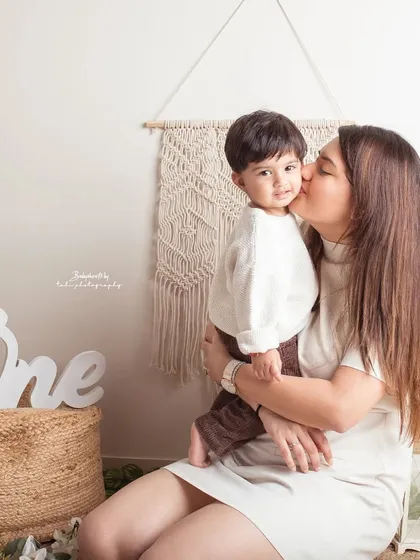 A sweet kiss from mom during a first birthday shoot. These are the tender moments that make the celebration even more special.