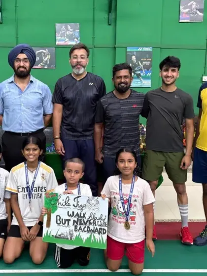 The coaches and a group of our younger summer camp participants. The sign says "Walk Tall, But Never Walk Backward," a motto we instill in our players.