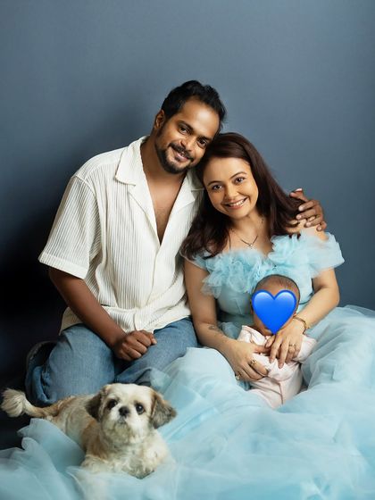 A relaxed family portrait on the floor, creating a casual and intimate feel. Including the family pet makes the picture complete.
