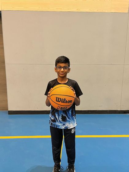 A player holds his ball, proud of his progress during the summer camp. It's rewarding to see their skills develop.