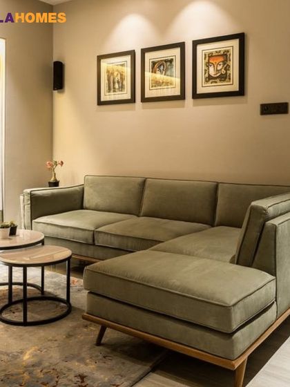 A minimalist living room with a comfortable L-shaped sofa in a soothing olive green. The nested coffee tables and simple wall art keep the look clean and modern.