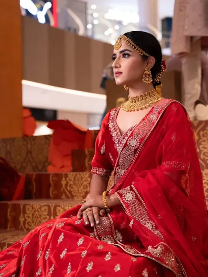 The complete look, from the detailed makeup to the beautiful red lehenga.