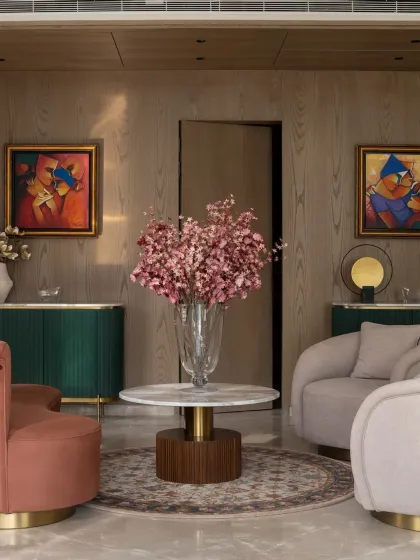 The entrance foyer of the Bhasin home, where curved furniture in terracotta and blush tones, a deep green console, and vibrant art create a warm and welcoming first impression.