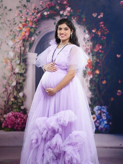 A beautiful mom-to-be posing in my lavender ruffle gown. The light color and soft fabric are perfect for creating a gentle and angelic look in your maternity photos.