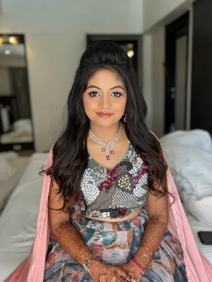 The full view of the carnival look. The client looks like a princess, with her fun eye makeup and voluminous hair.