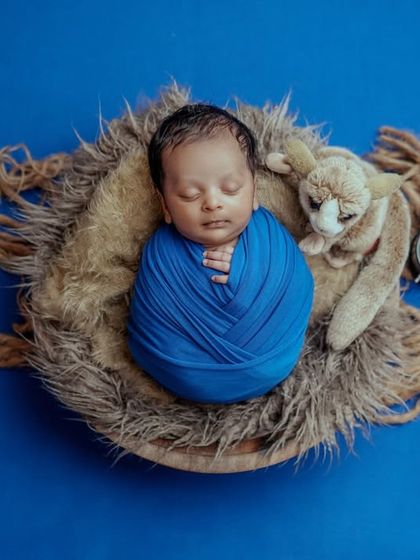Dreaming of adventures. This baby is swaddled in a nest of fur, creating a cozy and safe space for them to sleep while I capture their portrait.
