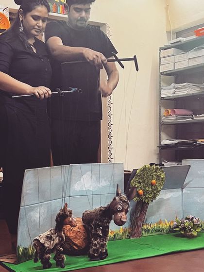 Our team operating animal puppets with a simple, hand-painted backdrop. Even simple setups can create magical stories.