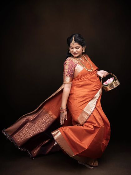 Wrapped in tradition, glowing in grace. This frame is a celebration of culture, strength, and the divine beauty of motherhood in an orange saree.