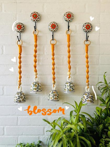 Our 'Blossom' macrame ceramic bells in a lovely mustard yellow. Available in a set of five with matching ceramic hooks, these bells are a perfect way to brighten up any space in your home.