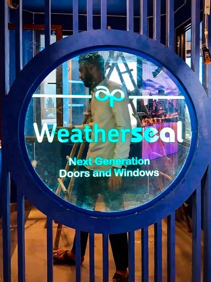 Custom branding is central to our experience center designs. Here, the 'Weatherseal' logo is integrated into a striking circular entryway, immediately immersing visitors in the brand's identity through bold colors and modern architectural signage.