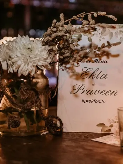 A simple and elegant bar menu card designed for a couple's reception. The personalized hashtag and romantic candlelight setting create a warm and inviting atmosphere.