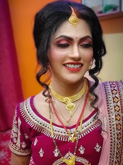 A radiant smile on a happy bride! I created this classic bridal look with bold red lips and defined eyes, complemented by a soft curly updo to complete her wedding day style.