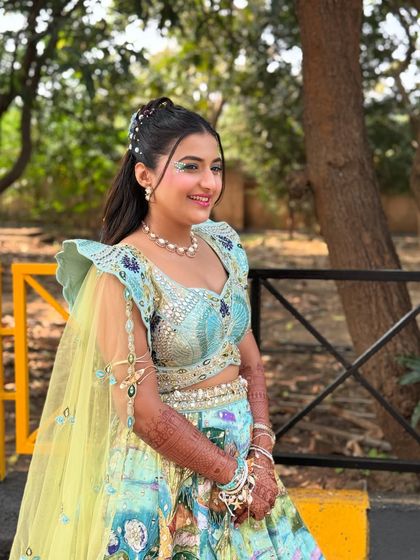 A full view of the carnival glam look. The hairstyle, with its colorful accessories and sparkling details, perfectly complements the bride's vibrant lehenga and fun-loving personality.