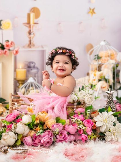 A dreamy floral portrait. This little girl, surrounded by soft pink flowers and pearls, looks like she's in a fairy tale.