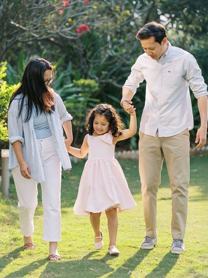 A family walking hand-in-hand through the park. A classic family photo that captures their unity and connection.