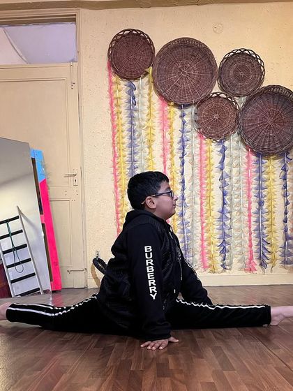 This student holds a perfect center split, showing excellent form and alignment. This is a result of regular practice and our detailed coaching.