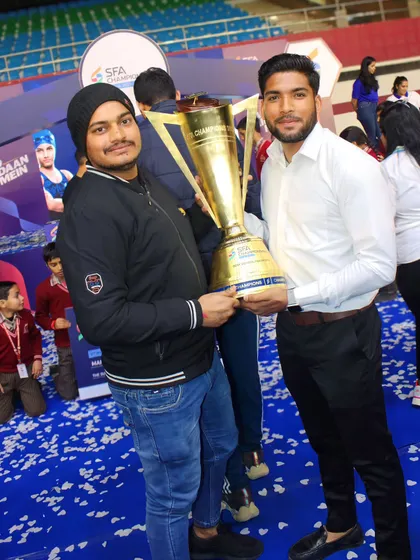 Holding the SFA Championship trophy with a fellow coach. Our combined efforts in Kabaddi and Kho-Kho lead to great results.