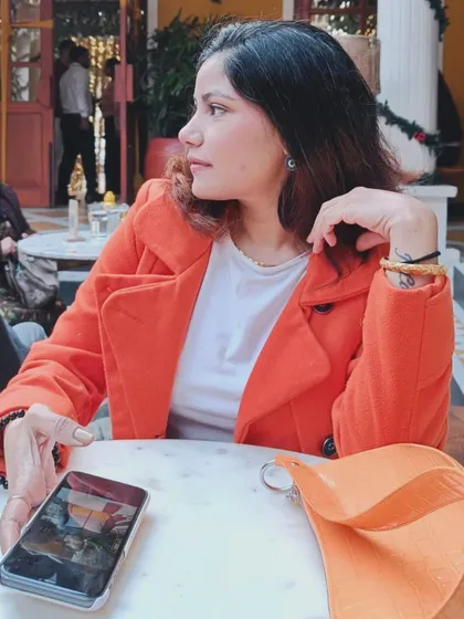 A side-profile shot at the cafe, highlighting the coat and my relaxed mood.