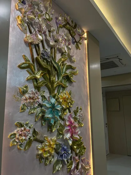The side angle reveals the beautiful texture and depth of the sculpted flowers and leaves.