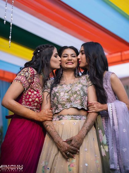 A sweet moment between the bride and her bridesmaids. Their makeup looks are coordinated to create a beautiful, unified aesthetic for the bridal party.