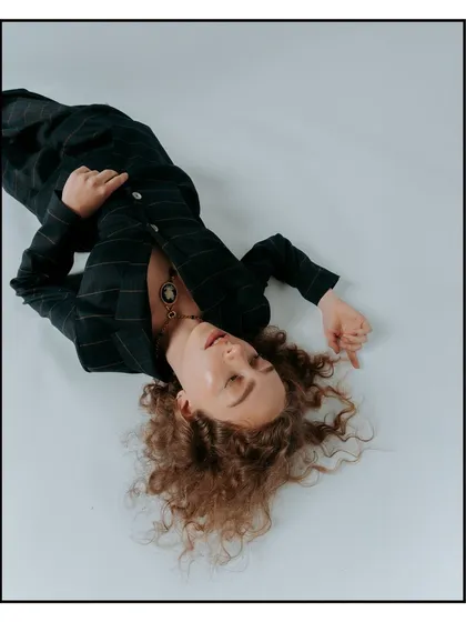 An overhead shot for a Flanelle Magazine editorial. The composition is unconventional, capturing the model in a moment of repose that highlights the tailoring of the suit.