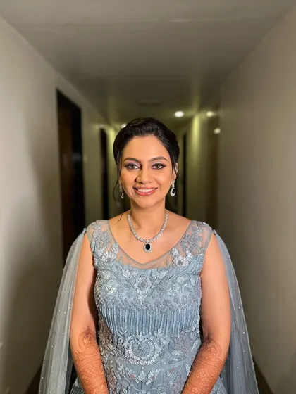 The client looking absolutely gorgeous and confident in her Sangeet outfit, with a hairstyle that is both modern and elegant.