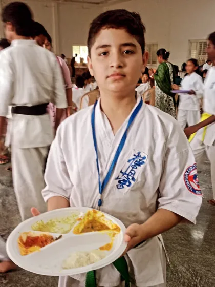 A young student proudly holds his plate. Proper nutrition is something I always emphasize, especially during a demanding competition.