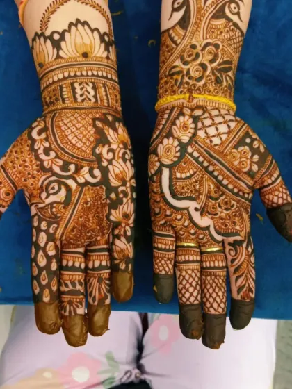 A beautiful pair of hands with a mix of peacock and floral motifs.