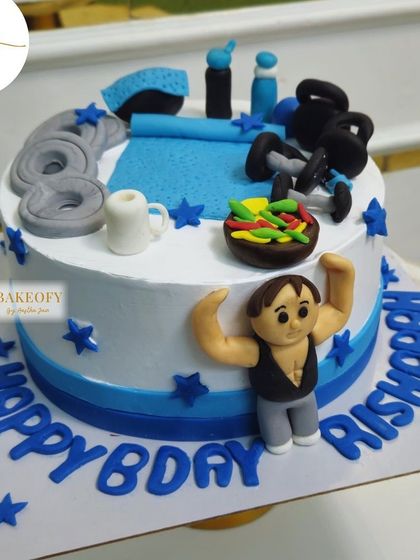 Pump up the celebration with this 1.5kg dark truffle cake for the ultimate gym freak. It's topped with fondant weights, a yoga mat, and even a tiny bowl of salad.